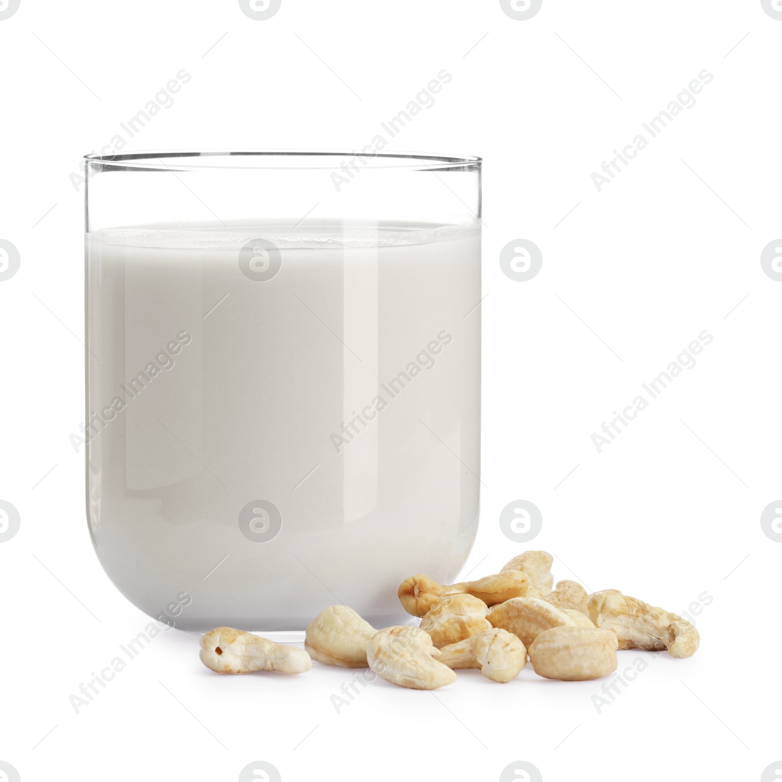 Photo of Fresh cashew milk in glass and nuts isolated on white