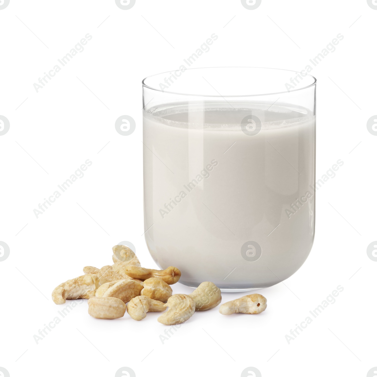 Photo of Fresh cashew milk in glass and nuts isolated on white