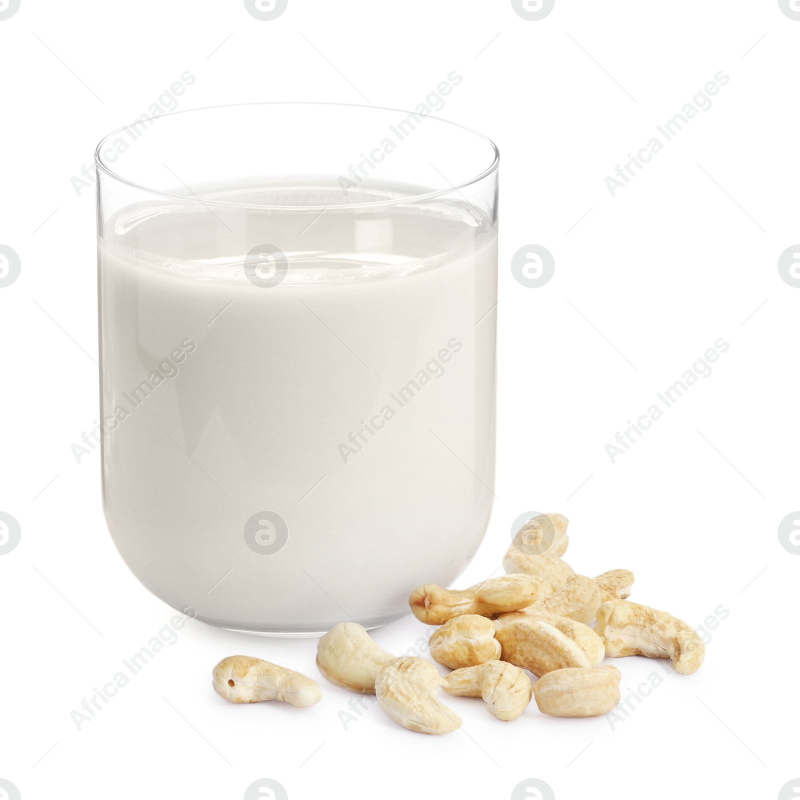 Photo of Fresh cashew milk in glass and nuts isolated on white