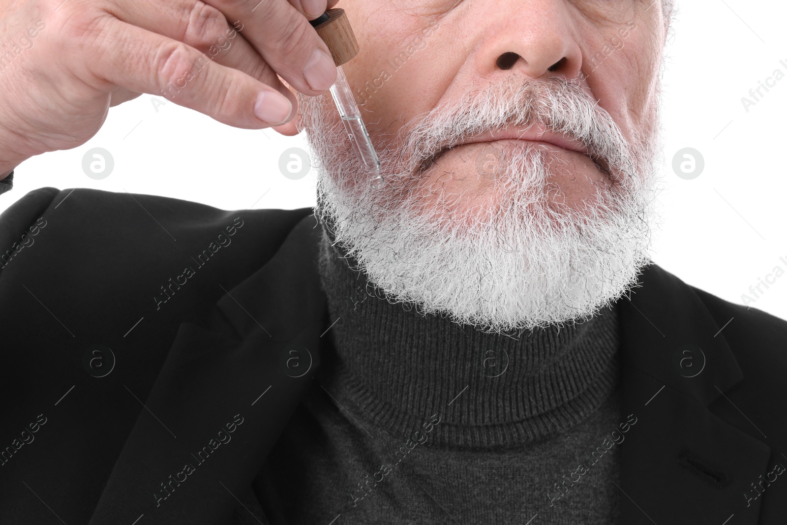 Photo of Senior man applying serum onto his beard on white background, closeup