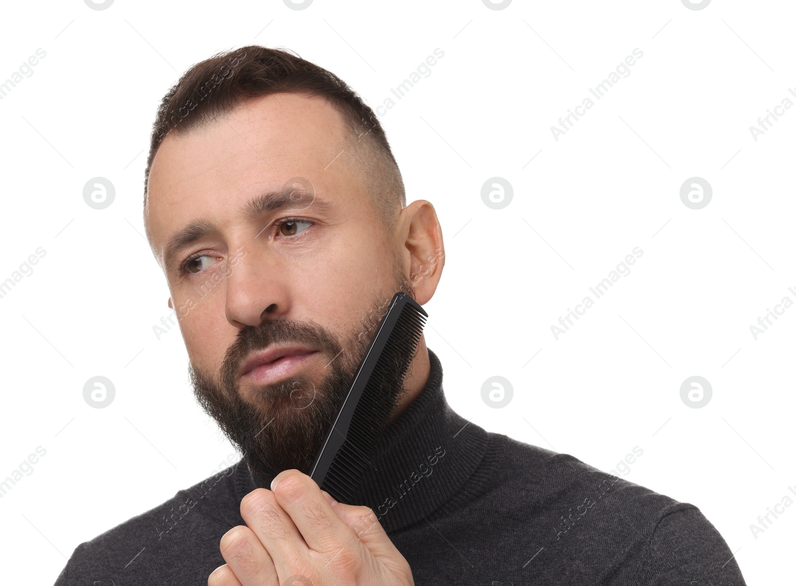 Photo of Handsome man combing beard on white background