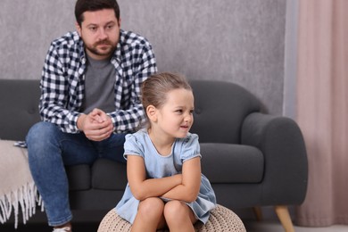 Photo of Resentful little girl and her father arguing at home, space for text