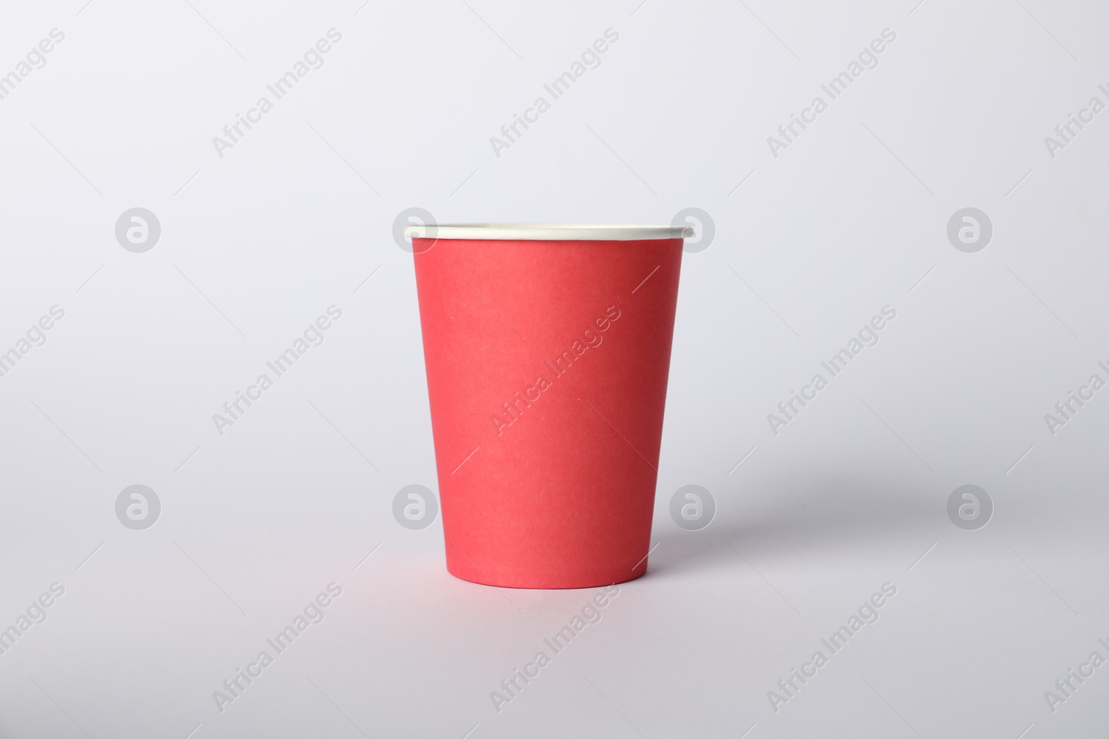 Photo of One paper cup on white background. Mockup for design