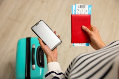 Traveller with passport, flight tickets and smartphone indoors, top view