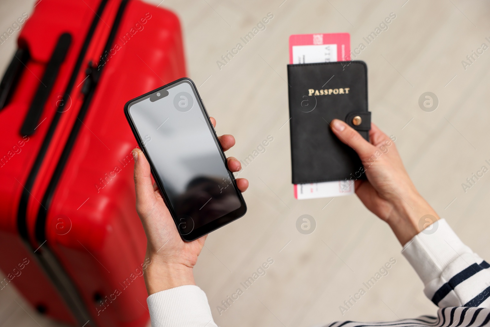 Photo of Traveller with passport, flight tickets and smartphone indoors, above view