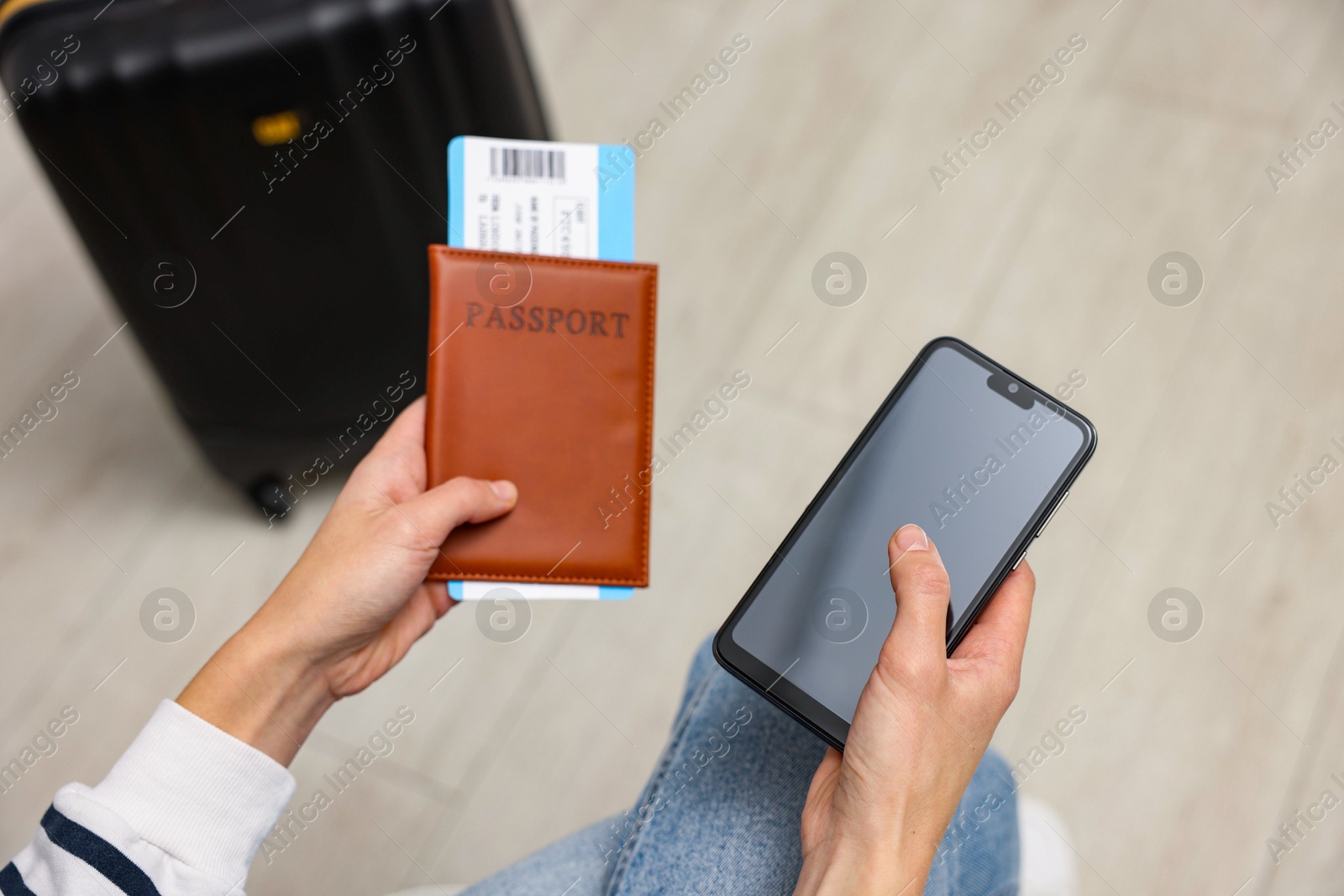 Photo of Traveller with passport, flight ticket and smartphone indoors, above view