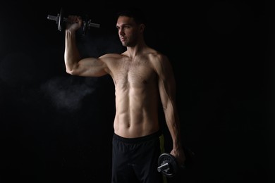 Photo of Man training with barbell on black background