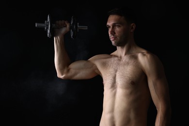 Photo of Man training with barbell on black background