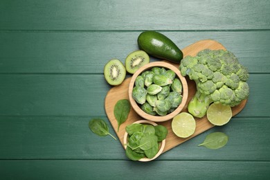 Photo of Different fresh healthy products on green wooden table, flat lay. Space for text