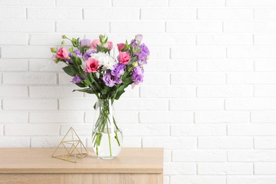 Photo of Vase with beautiful eustoma flowers on wooden chest of drawers, space for text