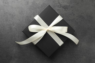 Photo of Gift box with bow on grey table, top view