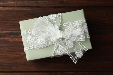 Photo of Gift box with bow on wooden table, top view