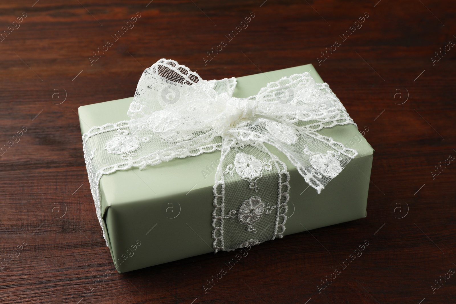 Photo of Gift box with bow on wooden table