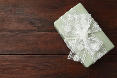 Photo of Gift box with bow on wooden table, top view. Space for text