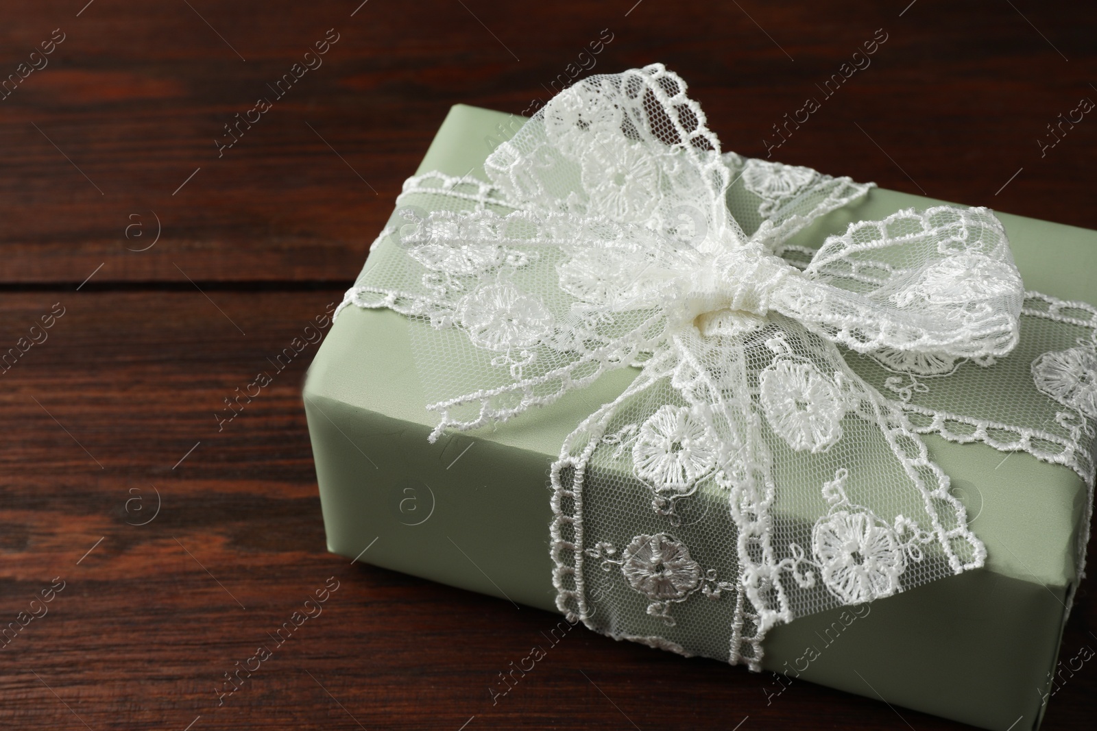 Photo of Gift box with bow on wooden table