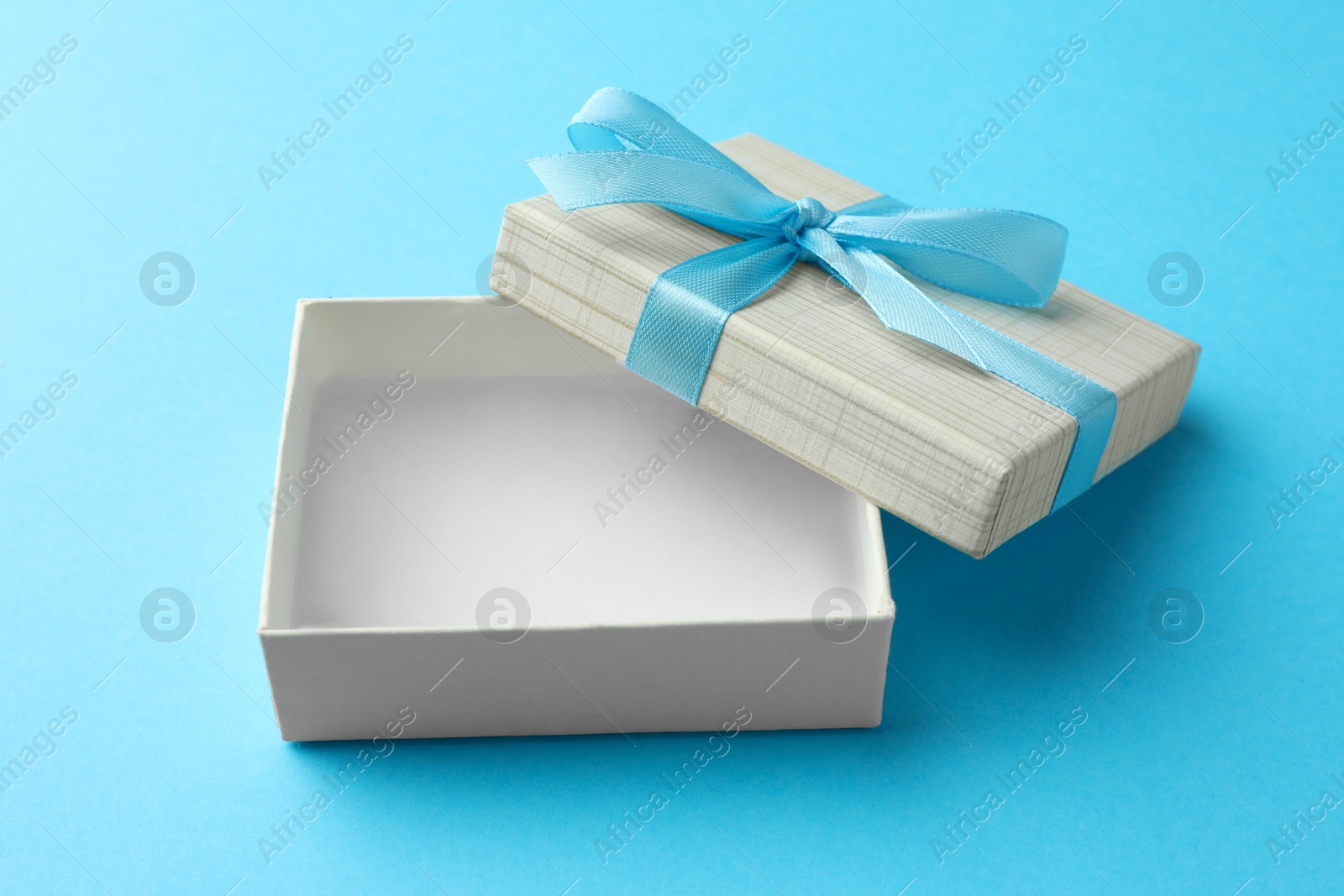 Photo of Gift box with bow on light blue background