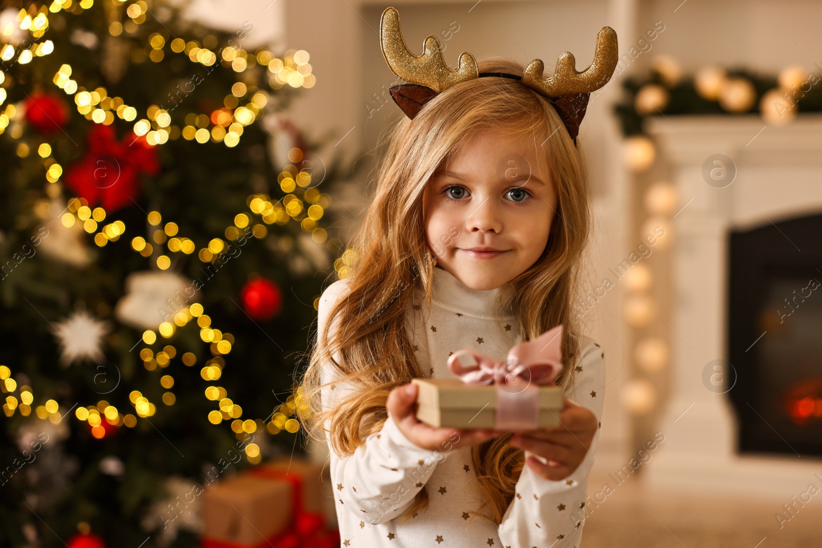 Photo of Little girl with Christmas gift at home