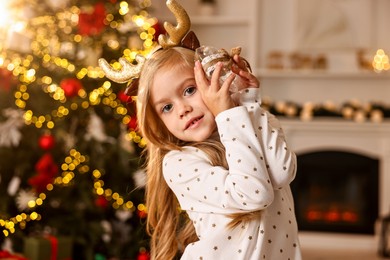 Little girl with Christmas ornament at home