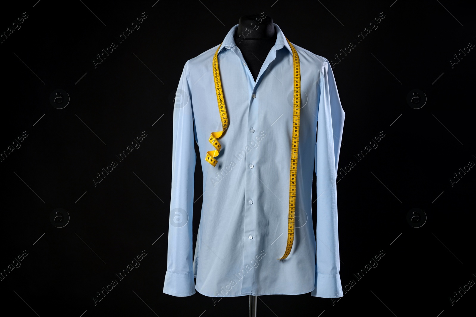 Photo of Male mannequin with shirt and measuring tape on black background