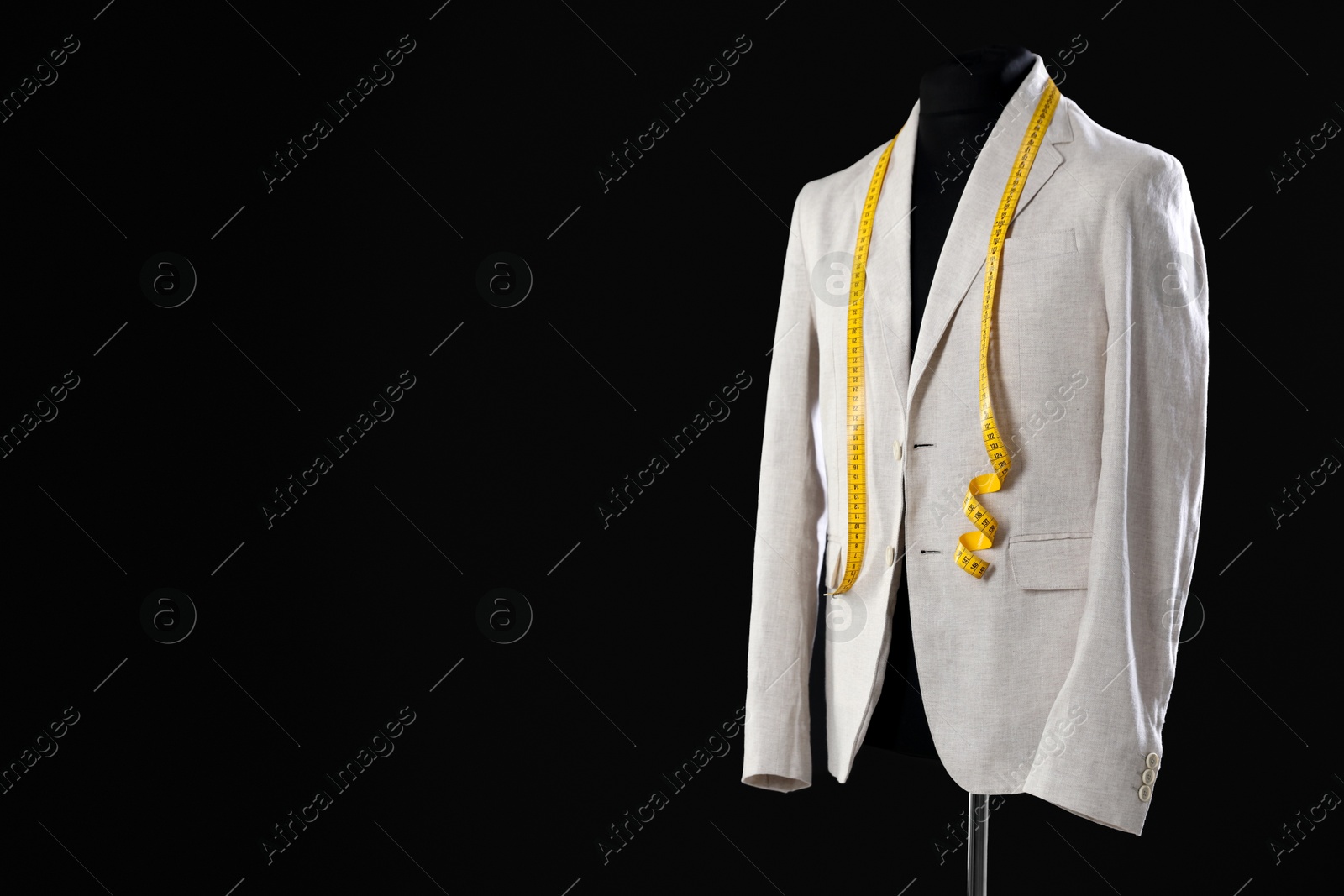 Photo of Male mannequin with jacket and measuring tape on black background, space for text