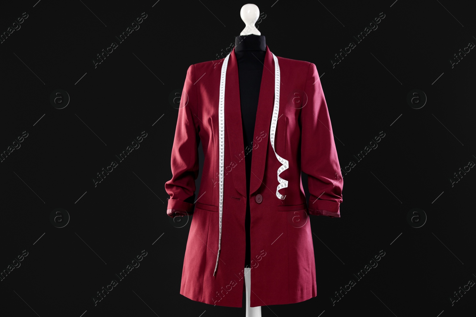 Photo of Female mannequin with stylish jacket and measuring tape on dark background