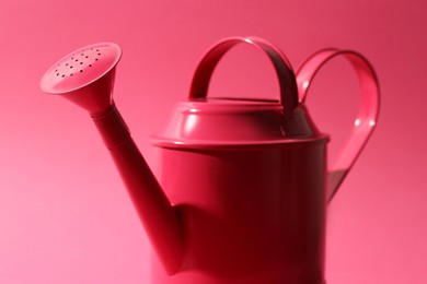 Photo of Metal watering can on bright pink background