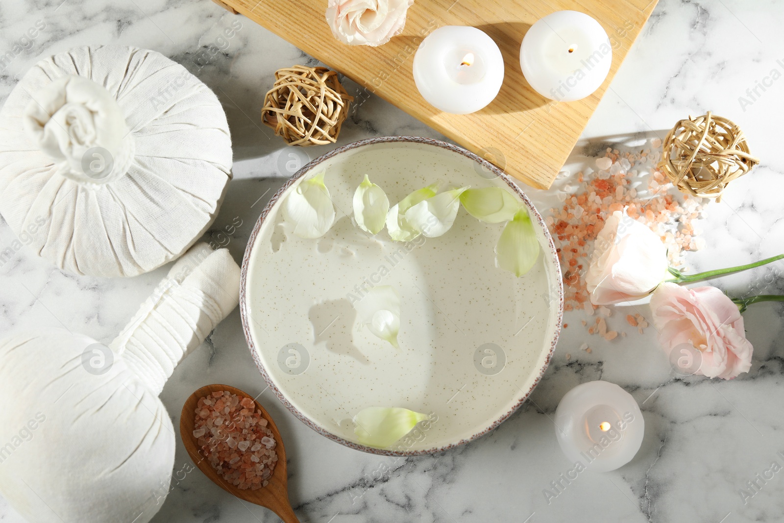 Photo of Spa composition with bowl of water and burning candles on white marble table, flat lay