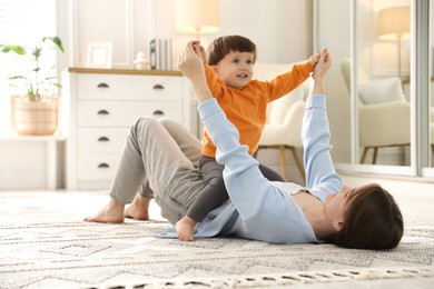 Photo of Mother playing her happy little son at home