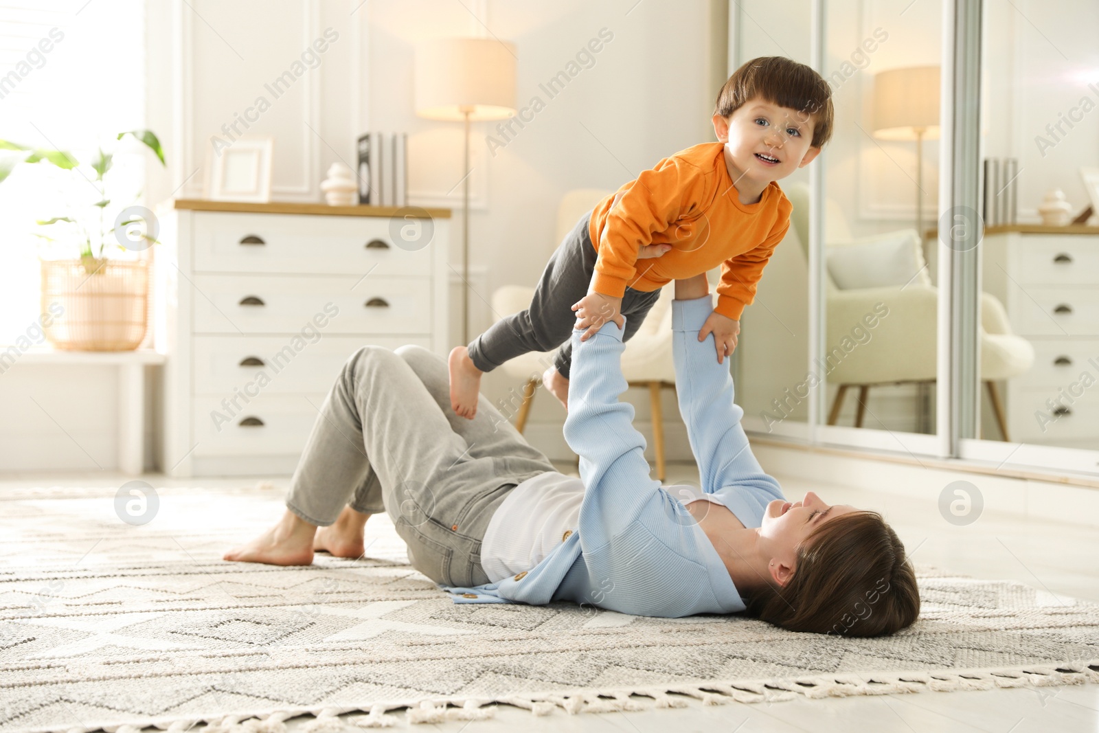 Photo of Mother playing her happy little son at home