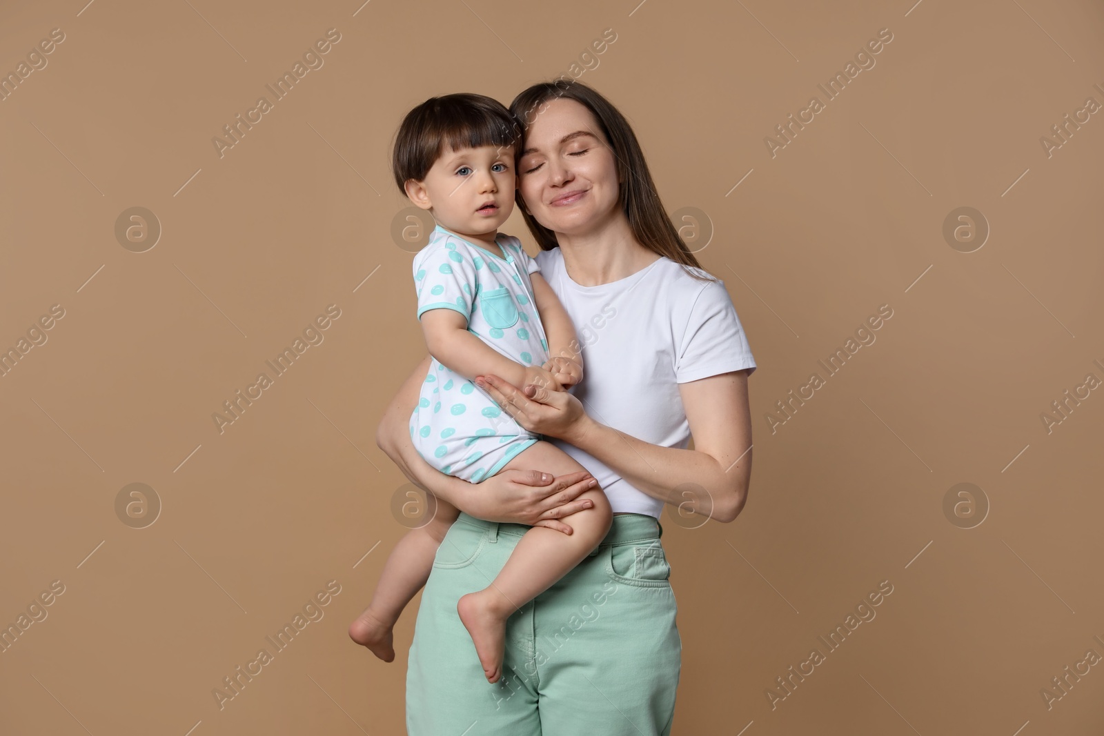 Photo of Family portrait of mother with her little son on beige background