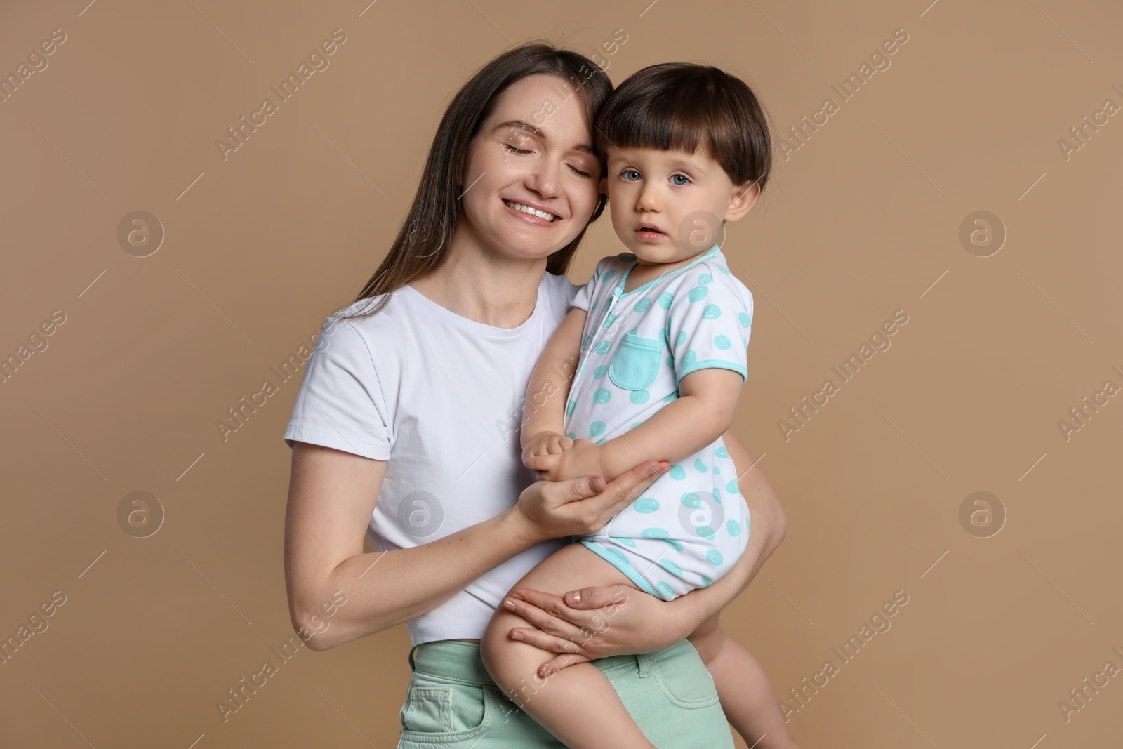 Photo of Family portrait of happy mother with her little son on beige background