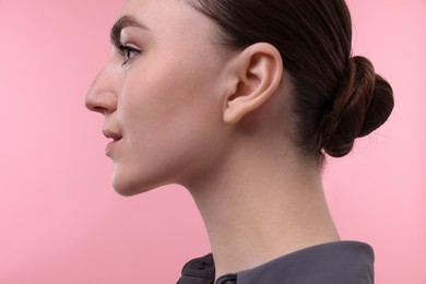 Portrait of beautiful woman on pink background, closeup