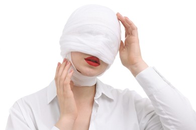 Woman with face wrapped in medical bandage after plastic surgery operation on white background