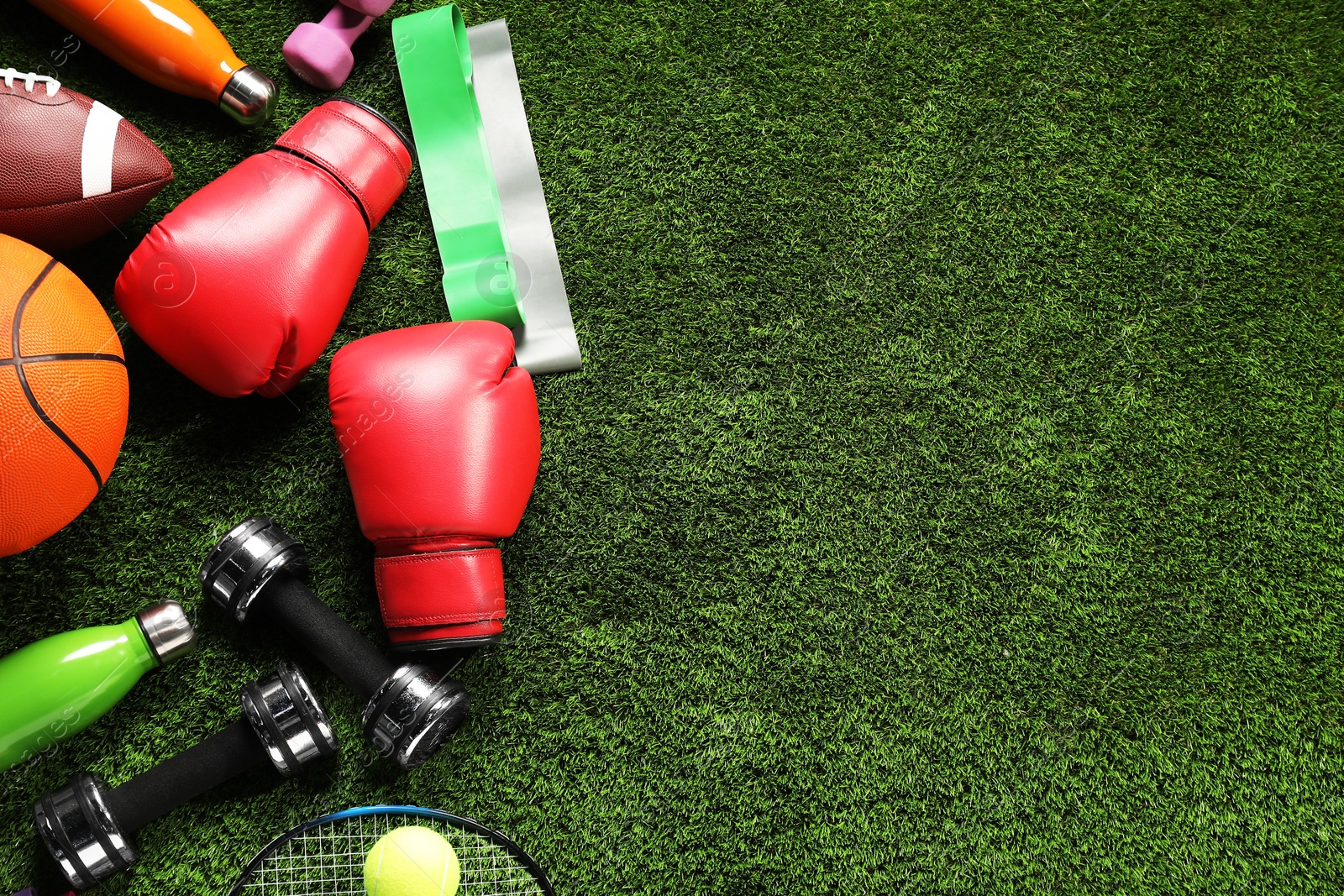 Photo of Different sports equipment on artificial grass, flat lay. Space for text