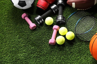 Photo of Different sports equipment on artificial grass, flat lay. Space for text