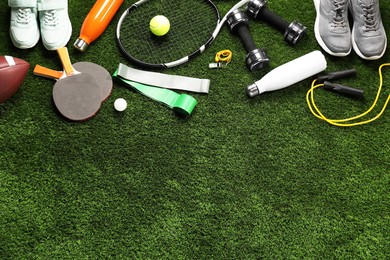 Different sports equipment on artificial grass, flat lay. Space for text