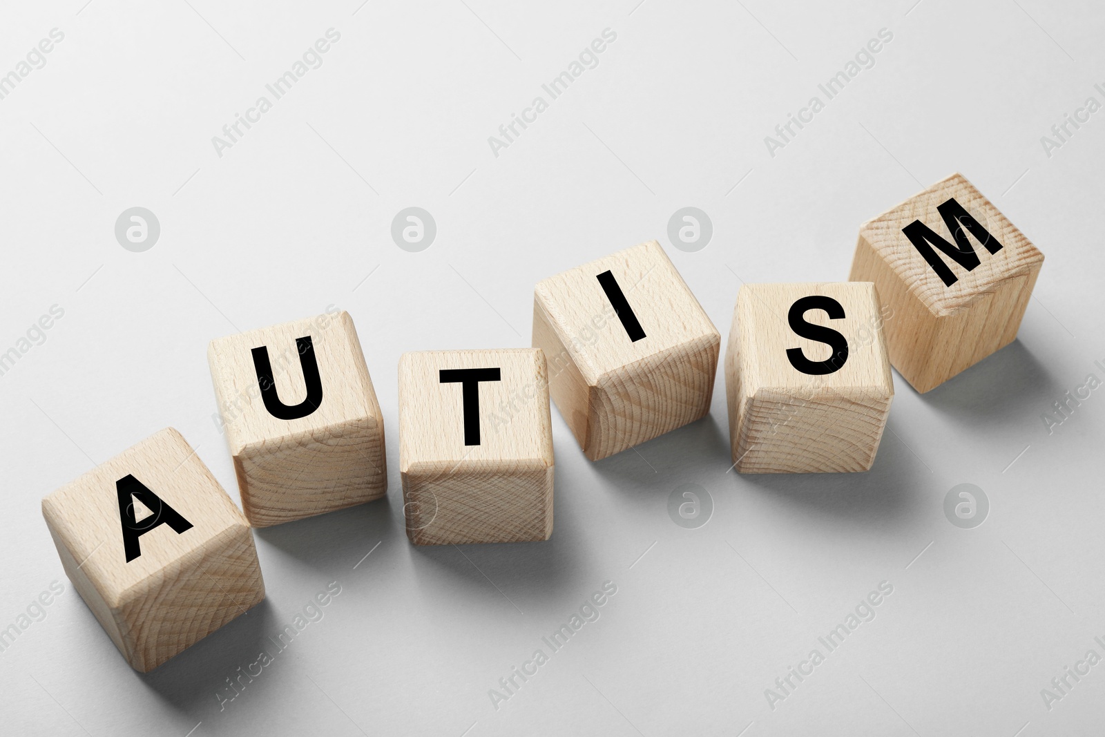 Photo of Word Autism made with wooden cubes on grey background, closeup