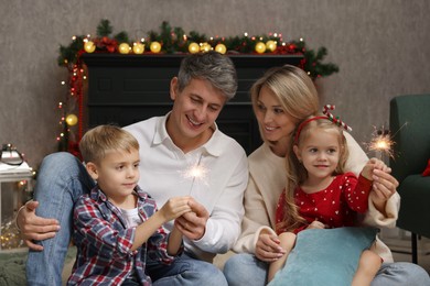 Lovely family with Christmas sparklers at home