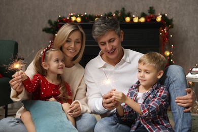 Photo of Lovely family with Christmas sparklers at home