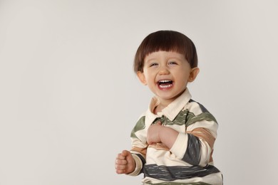 Photo of Emotional little boy on light grey background. Space for text