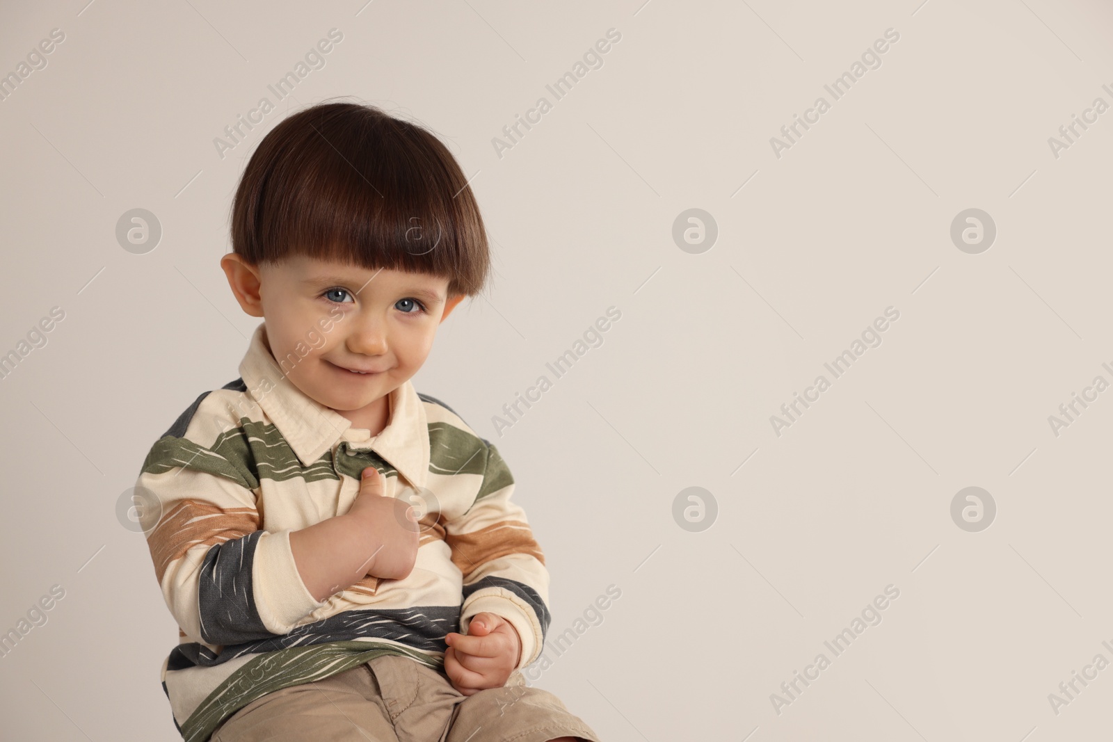 Photo of Cute little boy on light grey background. Space for text