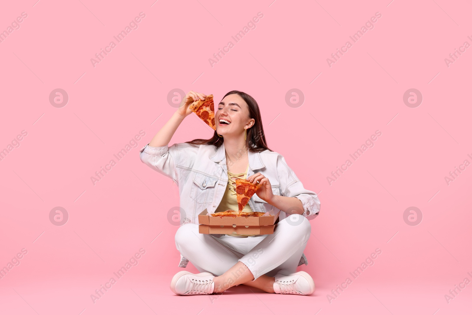 Photo of Beautiful woman with delicious pizza on pink background