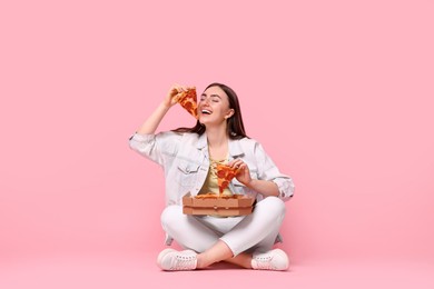 Beautiful woman with delicious pizza on pink background