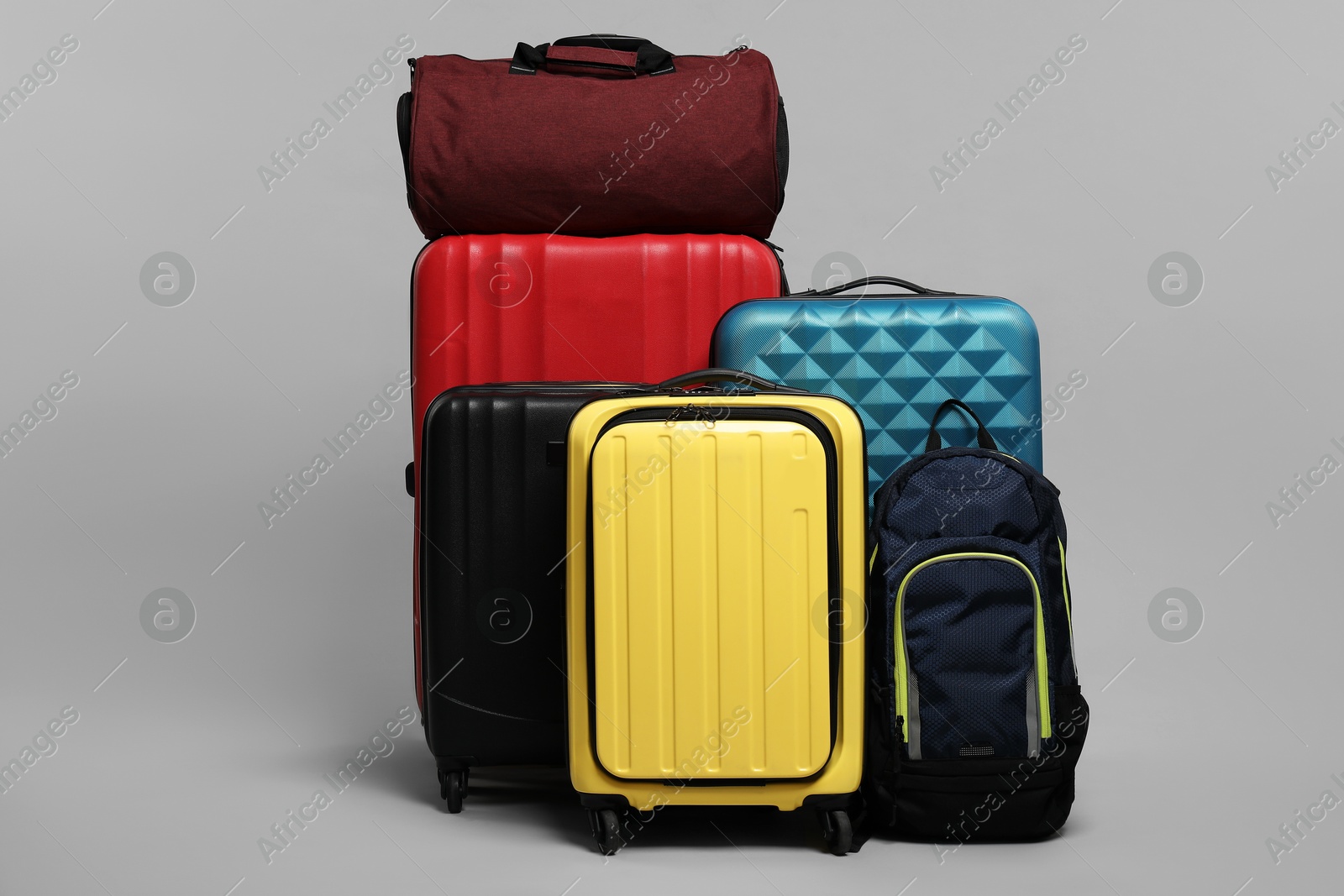 Photo of Many colorful suitcases, backpack and bag on grey background