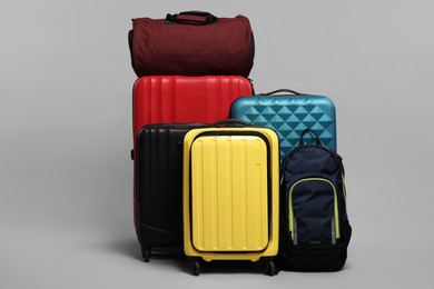 Photo of Many colorful suitcases, backpack and bag on grey background