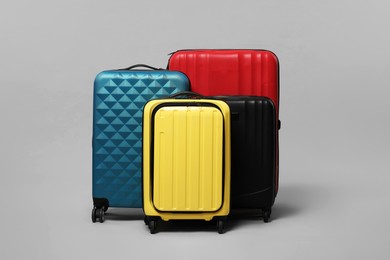 Photo of Many closed colorful suitcases on grey background