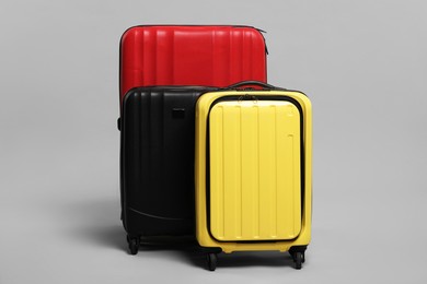 Photo of Many closed colorful suitcases on grey background