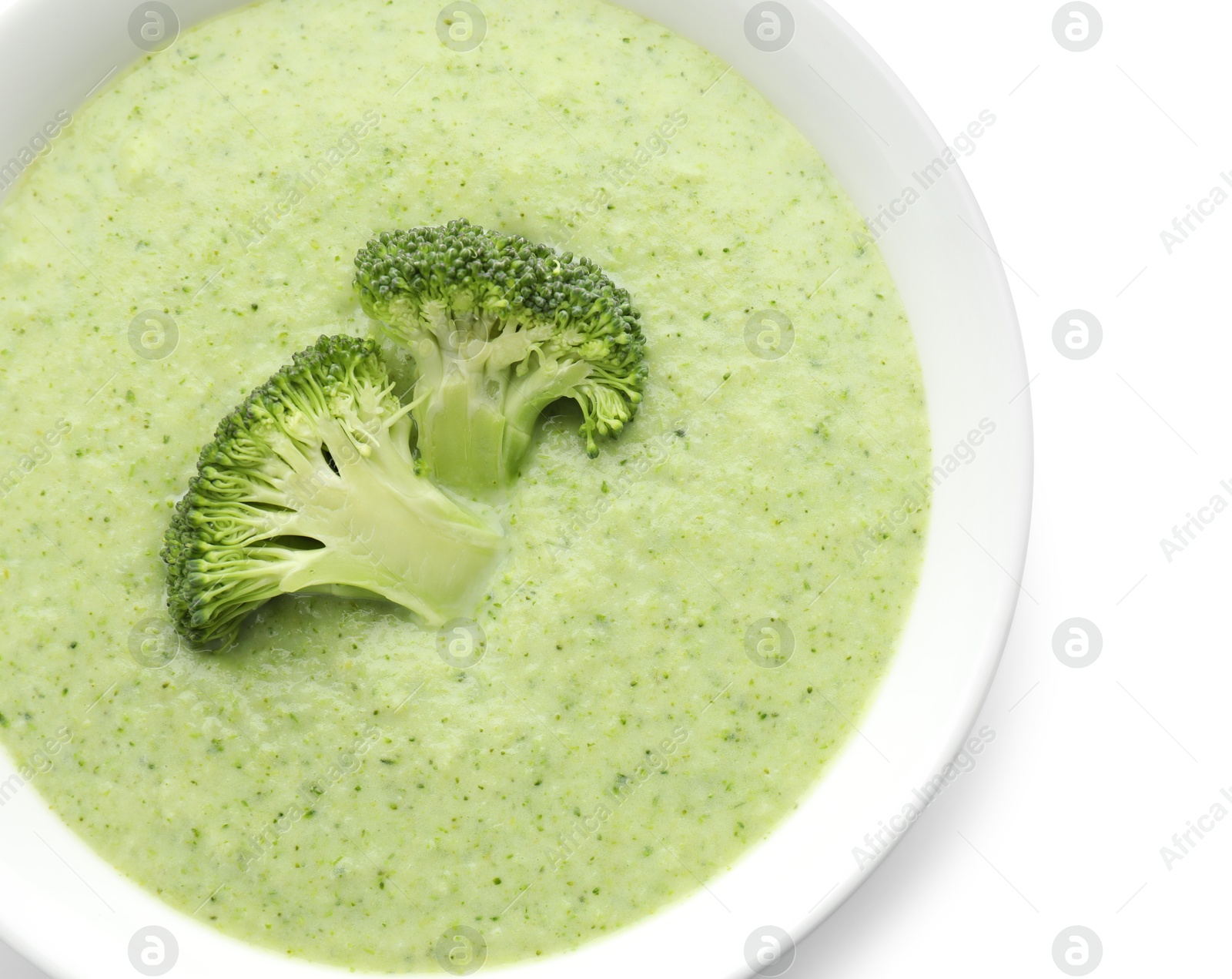 Photo of Delicious broccoli cream soup in bowl isolated on white, top view