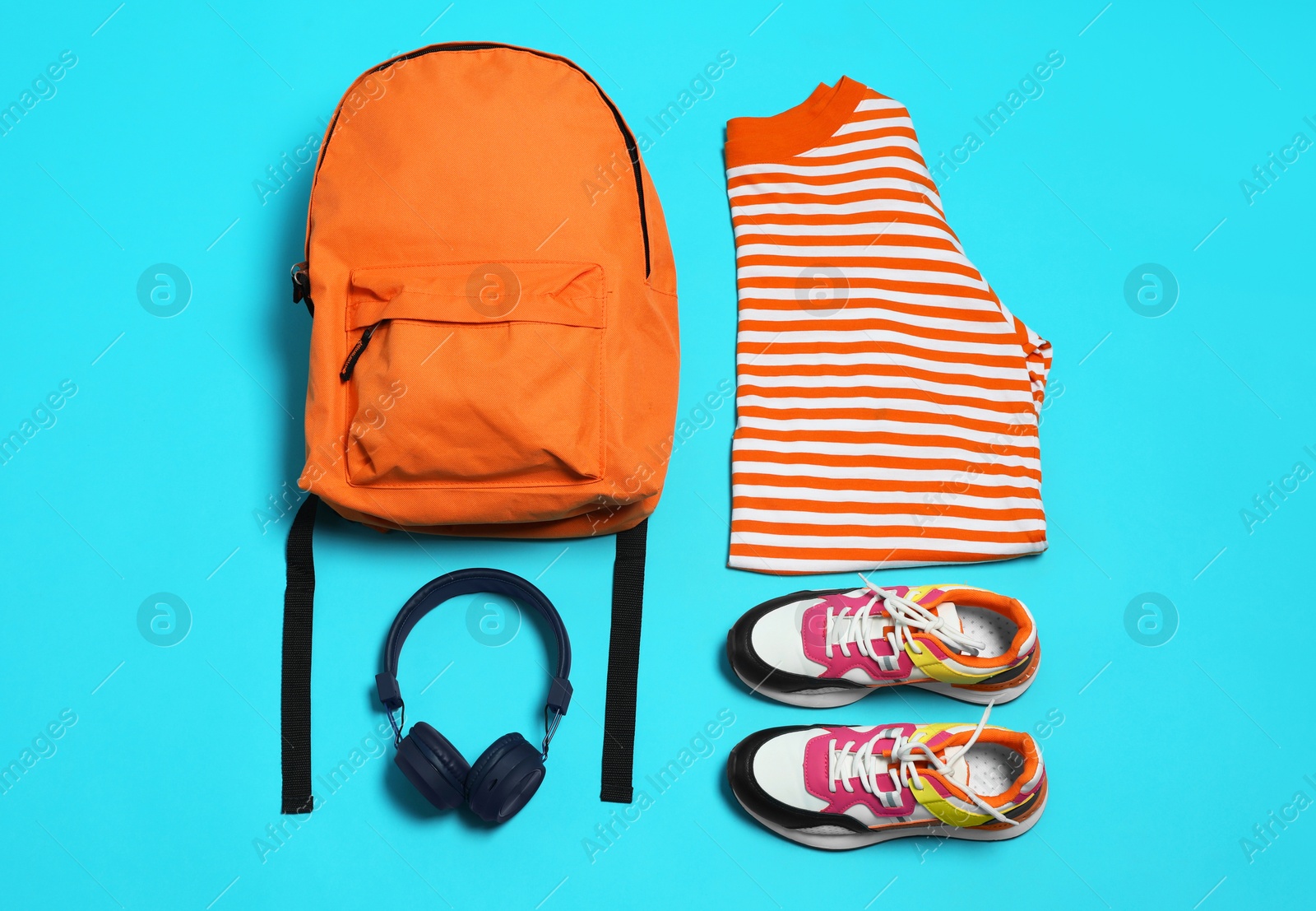 Photo of Stylish outfit with backpack on light blue background, flat lay