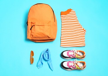 Photo of Stylish outfit with backpack on light blue background, flat lay